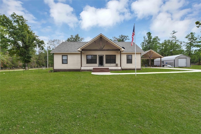 711 Forest Spgs, Livingston, TX 77351 - view of front of home with a front yard, an outdoor structure, a shingled roof, and a carport