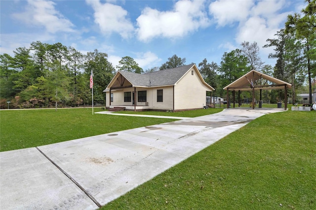 711 Forest Spgs, Livingston, TX 77351 - back of property with driveway, a detached carport, and a lawn
