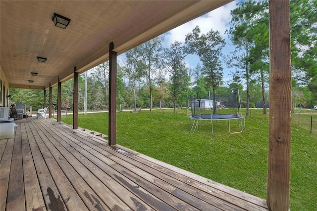 711 Forest Spgs, Livingston, TX 77351 - wooden terrace with a trampoline, a yard, and view of scattered trees