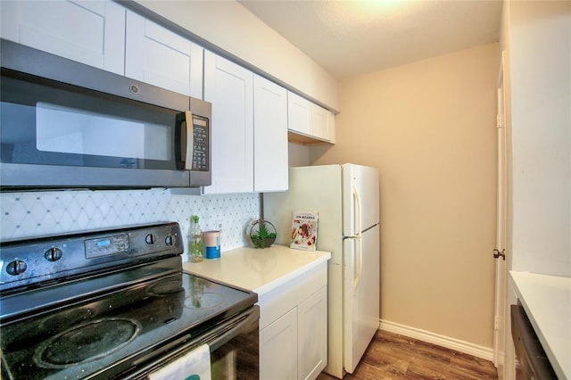 10075 Westpark Dr Unit 45, Houston, TX 77042 - kitchen featuring stainless steel microwave, electric range, wood finished floors, white cabinetry, and light countertops
