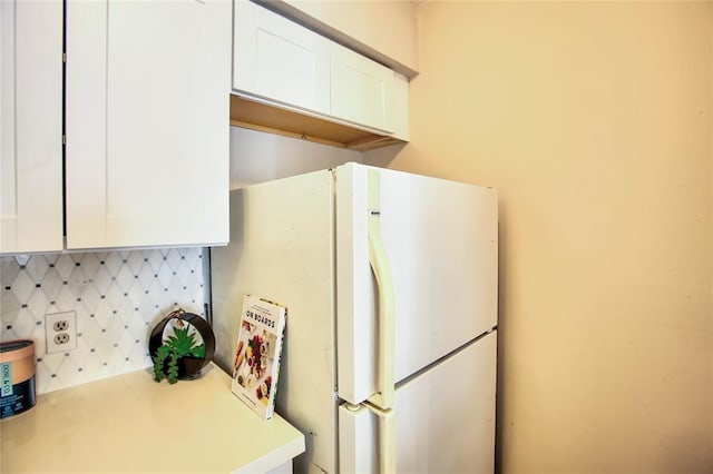10075 Westpark Dr Unit 45, Houston, TX 77042 - kitchen featuring freestanding refrigerator, white cabinetry, light countertops, and backsplash