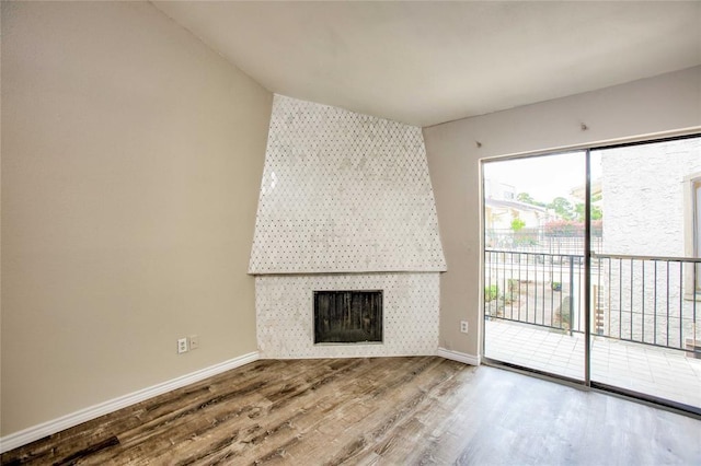 10075 Westpark Dr Unit 45, Houston, TX 77042 - unfurnished living room featuring a fireplace, wood finished floors, and baseboards