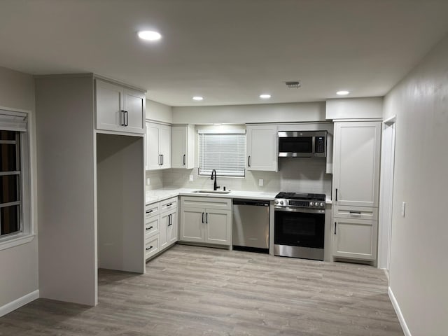 3706 Galway Ln, Houston, TX 77080 - kitchen with stainless steel appliances, a sink, decorative backsplash, light countertops, and light wood-type flooring