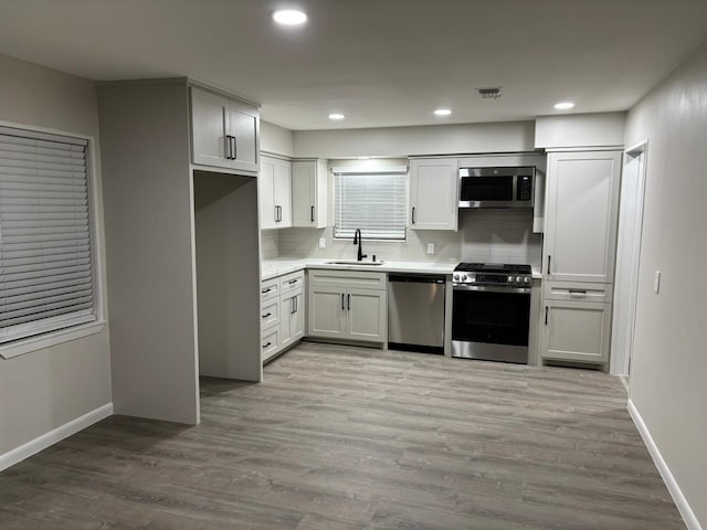 3706 Galway Ln, Houston, TX 77080 - kitchen featuring stainless steel appliances, a sink, tasteful backsplash, baseboards, and light countertops