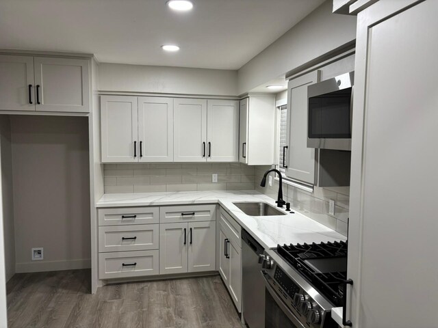 3706 Galway Ln, Houston, TX 77080 - kitchen with stainless steel appliances, a sink, light stone countertops, recessed lighting, and decorative backsplash