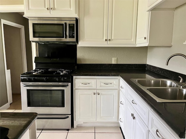 3134 7th Ave N, Texas City, TX 77590 - kitchen featuring stainless steel appliances, a sink, light tile patterned floors, and dark countertops