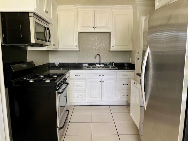 3134 7th Ave N, Texas City, TX 77590 - kitchen with stainless steel appliances, a sink, dark countertops, and light tile patterned floors