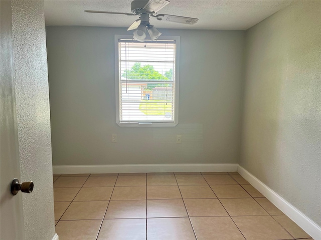 3134 7th Ave N, Texas City, TX 77590 - empty room featuring a ceiling fan, a textured ceiling, light tile patterned floors, a textured wall, and baseboards