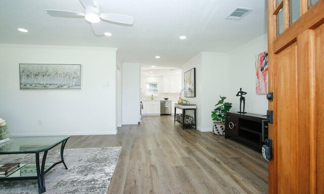 5313 De Lange Ln, Houston, TX 77092 - living area with crown molding, wood finished floors, a ceiling fan, and recessed lighting