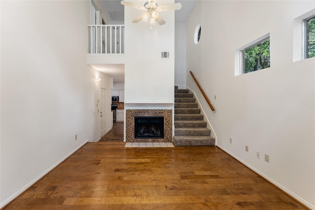 5515 Strack Rd Unit 101, Houston, TX 77069 - unfurnished living room with a high ceiling, a ceiling fan, wood finished floors, a fireplace, and baseboards