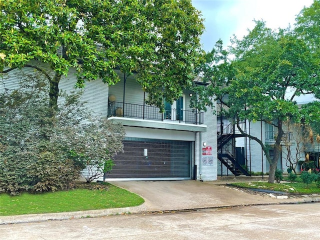 3300 Yorktown St Unit 17, Houston, TX 77056 - view of front of home featuring stairway, a balcony, a garage, driveway, and brick siding
