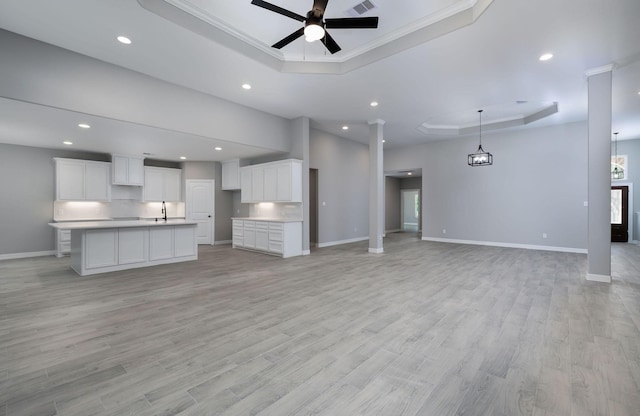 307 Grand Vw, Huntsville, TX 77340 - unfurnished living room with a raised ceiling, a sink, ceiling fan, recessed lighting, and baseboards