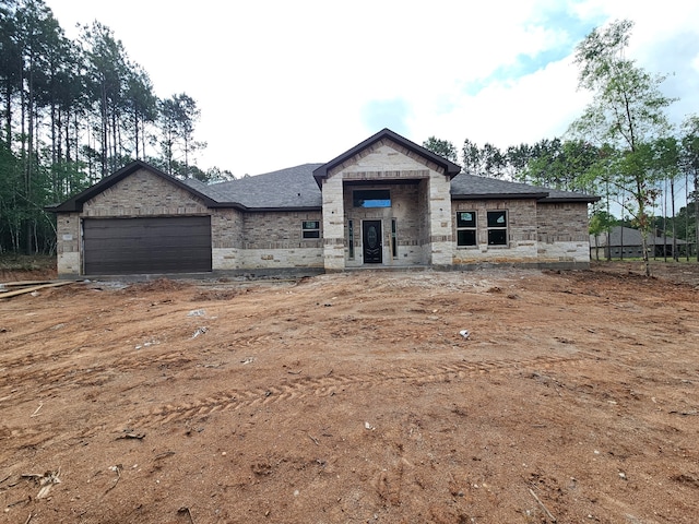 307 Grand Vw, Huntsville, TX 77340 - view of front of home with an attached garage, brick siding, roof with shingles, and stone siding