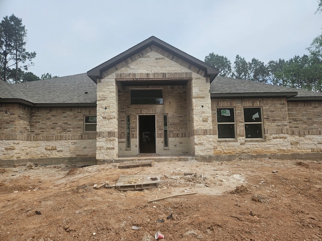 307 Grand Vw, Huntsville, TX 77340 - view of exterior entry with a shingled roof and stone siding
