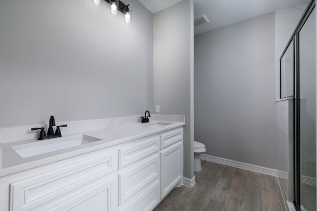307 Grand Vw, Huntsville, TX 77340 - bathroom with toilet, a shower with shower door, wood finished floors, and double vanity