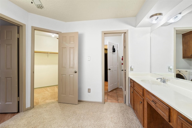 3336 Thornwood Way, Huntsville, TX 77340 - bathroom featuring washer / dryer, vanity, carpet floors, baseboards, and a closet