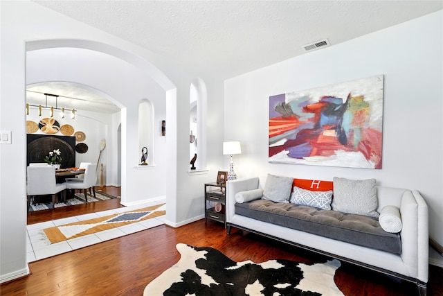 8210 Edenwood Dr, Spring, TX 77389 - living area with wood finished floors, arched walkways, a textured ceiling, and baseboards