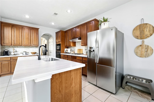 8210 Edenwood Dr, Spring, TX 77389 - kitchen with black appliances, a sink, under cabinet range hood, arched walkways, and light tile patterned floors