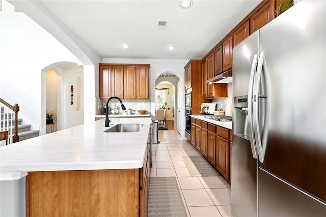 8210 Edenwood Dr, Spring, TX 77389 - kitchen featuring stainless steel appliances, under cabinet range hood, a sink, light countertops, and decorative backsplash