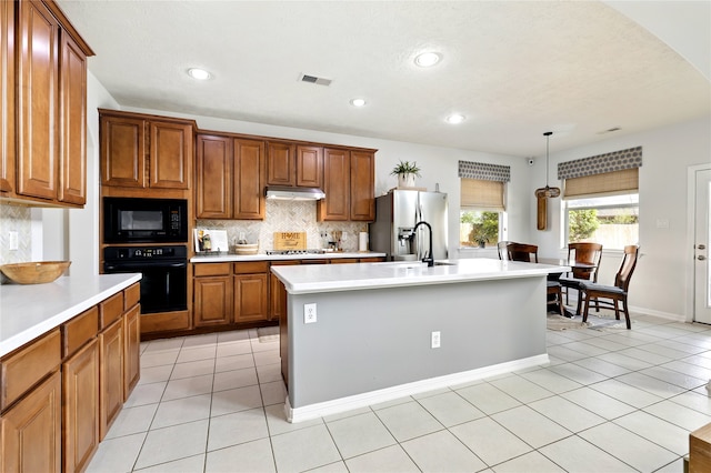 8210 Edenwood Dr, Spring, TX 77389 - kitchen with black appliances, under cabinet range hood, brown cabinets, light countertops, and recessed lighting