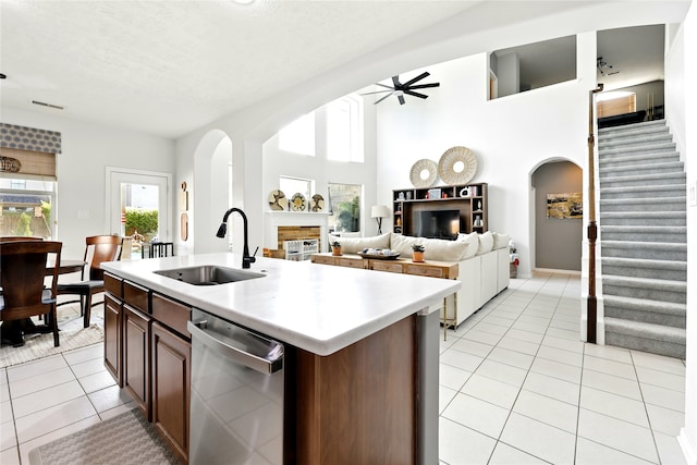8210 Edenwood Dr, Spring, TX 77389 - kitchen with stainless steel dishwasher, a sink, ceiling fan, light tile patterned floors, and light countertops