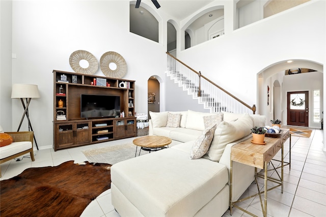 8210 Edenwood Dr, Spring, TX 77389 - living room featuring arched walkways, a high ceiling, tile patterned flooring, and baseboards