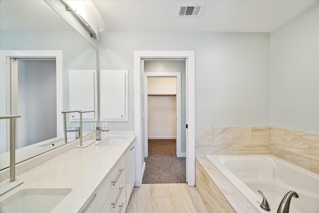 616 Lester St, Houston, TX 77007 - full bathroom with double vanity, a bath, a spacious closet, and baseboards
