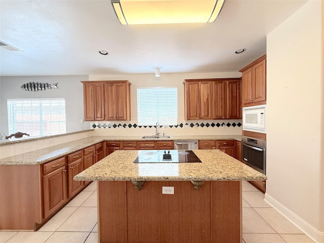 522 Chickory Field Ln, Pearland, TX 77584 - kitchen featuring stainless steel appliances, a sink, light tile patterned floors, a peninsula, and backsplash