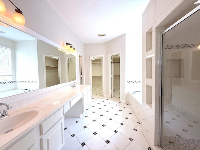 522 Chickory Field Ln, Pearland, TX 77584 - bathroom featuring a garden tub, a stall shower, a walk in closet, double vanity, and tile patterned floors