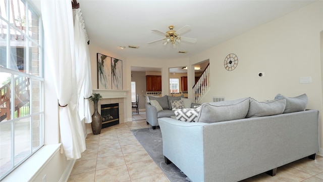 522 Chickory Field Ln, Pearland, TX 77584 - living area with stairs, light tile patterned flooring, a ceiling fan, a tile fireplace, and baseboards
