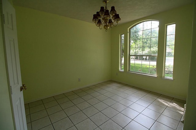 105 N Hollylaurel Cir, The Woodlands, TX 77382 - spare room with a chandelier, light tile patterned flooring, and baseboards