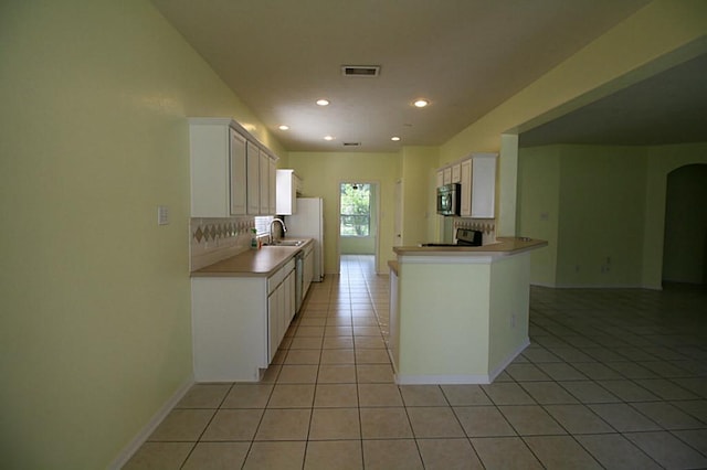 105 N Hollylaurel Cir, The Woodlands, TX 77382 - kitchen with light tile patterned floors, decorative backsplash, a sink, recessed lighting, and stainless steel appliances