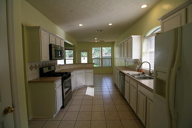 105 N Hollylaurel Cir, The Woodlands, TX 77382 - kitchen featuring appliances with stainless steel finishes, a sink, backsplash, recessed lighting, and light tile patterned floors