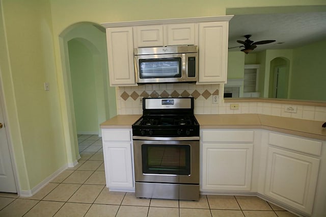 105 N Hollylaurel Cir, The Woodlands, TX 77382 - kitchen featuring appliances with stainless steel finishes, decorative backsplash, and light tile patterned floors
