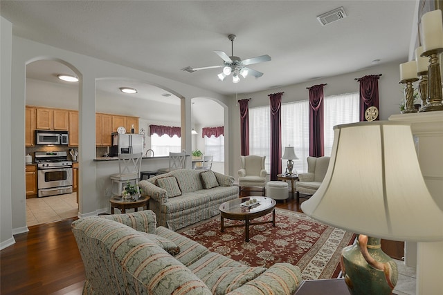 8810 Sailing Dr, Humble, TX 77346 - living area with ceiling fan, arched walkways, plenty of natural light, and light wood finished floors