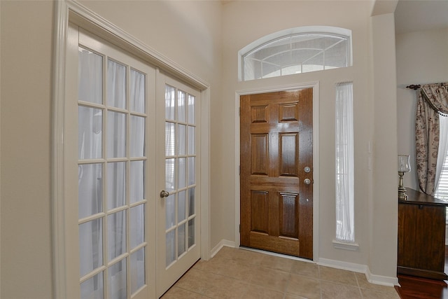 8810 Sailing Dr, Humble, TX 77346 - foyer with french doors, light tile patterned flooring, plenty of natural light, and baseboards