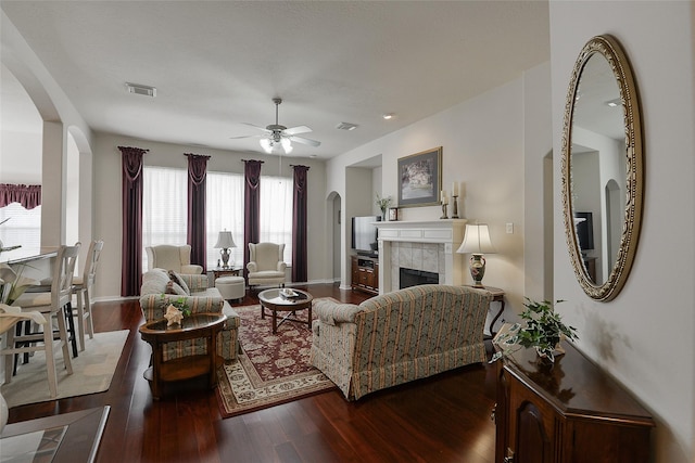 8810 Sailing Dr, Humble, TX 77346 - living area featuring ceiling fan, arched walkways, wood finished floors, a tiled fireplace, and baseboards