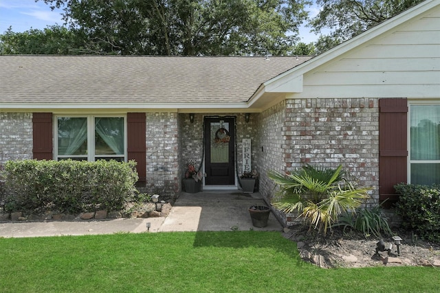 31047 Torrey Rd, Waller, TX 77484 - view of exterior entry with roof with shingles, a lawn, and brick siding