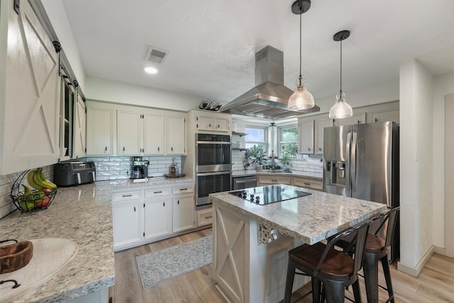 31047 Torrey Rd, Waller, TX 77484 - kitchen with stainless steel appliances, light wood finished floors, a center island, decorative backsplash, and recessed lighting
