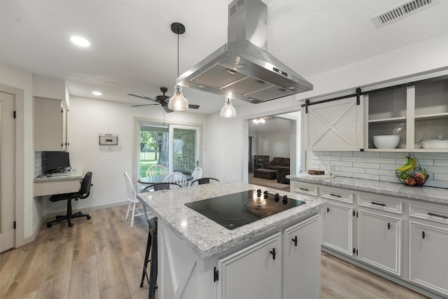 31047 Torrey Rd, Waller, TX 77484 - kitchen featuring island exhaust hood, black electric stovetop, ceiling fan, a center island, and decorative backsplash