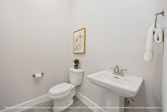 1818 Colquitt St, Houston, TX 77098 - bathroom featuring baseboards, toilet, tile patterned floors, and a sink
