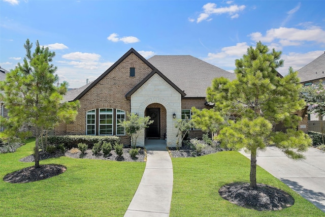 15240 Hemingway Heights Dr, Conroe, TX 77302 - view of front of property featuring brick siding, a front lawn, a shingled roof, and stone siding