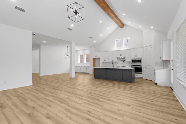 15240 Hemingway Heights Dr, Conroe, TX 77302 - kitchen featuring a chandelier, stainless steel appliances, beam ceiling, white cabinetry, and open floor plan