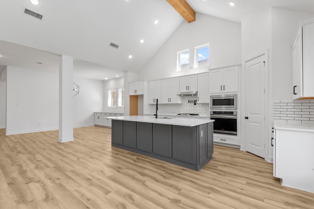 15240 Hemingway Heights Dr, Conroe, TX 77302 - kitchen with appliances with stainless steel finishes, beam ceiling, a sink, high vaulted ceiling, and light countertops