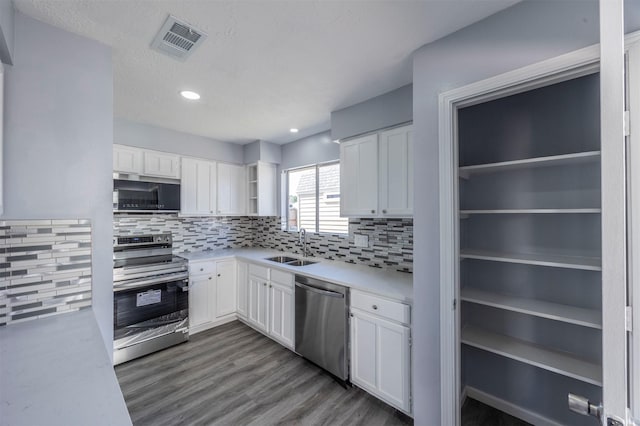 11919 Bald Mountain Cir, Houston, TX 77067 - kitchen with stainless steel appliances, a sink, white cabinets, and recessed lighting