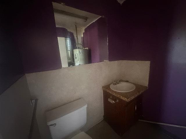8008 De Priest St, Houston, TX 77088 - half bathroom featuring water heater, vanity, and toilet