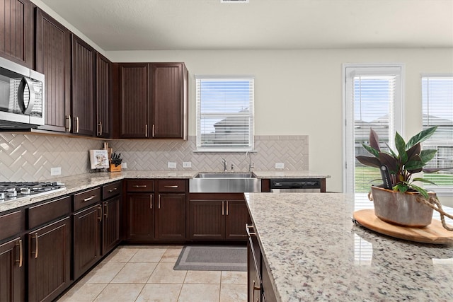 25419 Whitehaven Gate St, Katy, TX 77493 - kitchen with a sink, stainless steel appliances, backsplash, light tile patterned flooring, and dark brown cabinets