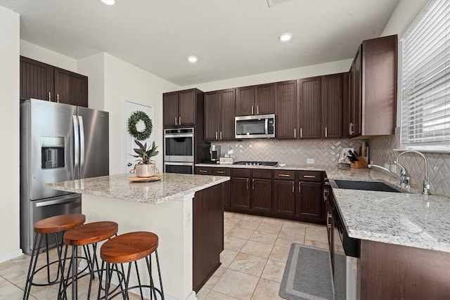 25419 Whitehaven Gate St, Katy, TX 77493 - kitchen featuring stainless steel appliances, a sink, a center island, a breakfast bar area, and backsplash