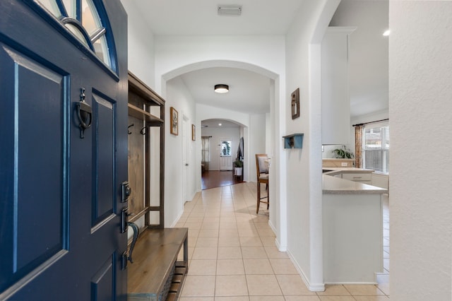 6103 Moran Crest Dr, Spring, TX 77388 - entryway featuring arched walkways, light tile patterned flooring, and baseboards