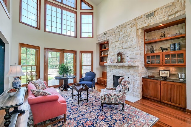 5318 Westerham St, Fulshear, TX 77441 - living room featuring wood finished floors, a fireplace, a towering ceiling, and plenty of natural light